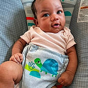 Soraya is registered to the contest to win money with this photo: baby, infant, child, cute, smiling, baby_seat, turtle_design, clothing, pink_outfit, curly_hair, hand, legs, indoor, colorful, playful, comfort, portrait, young_child, adorable, relaxed