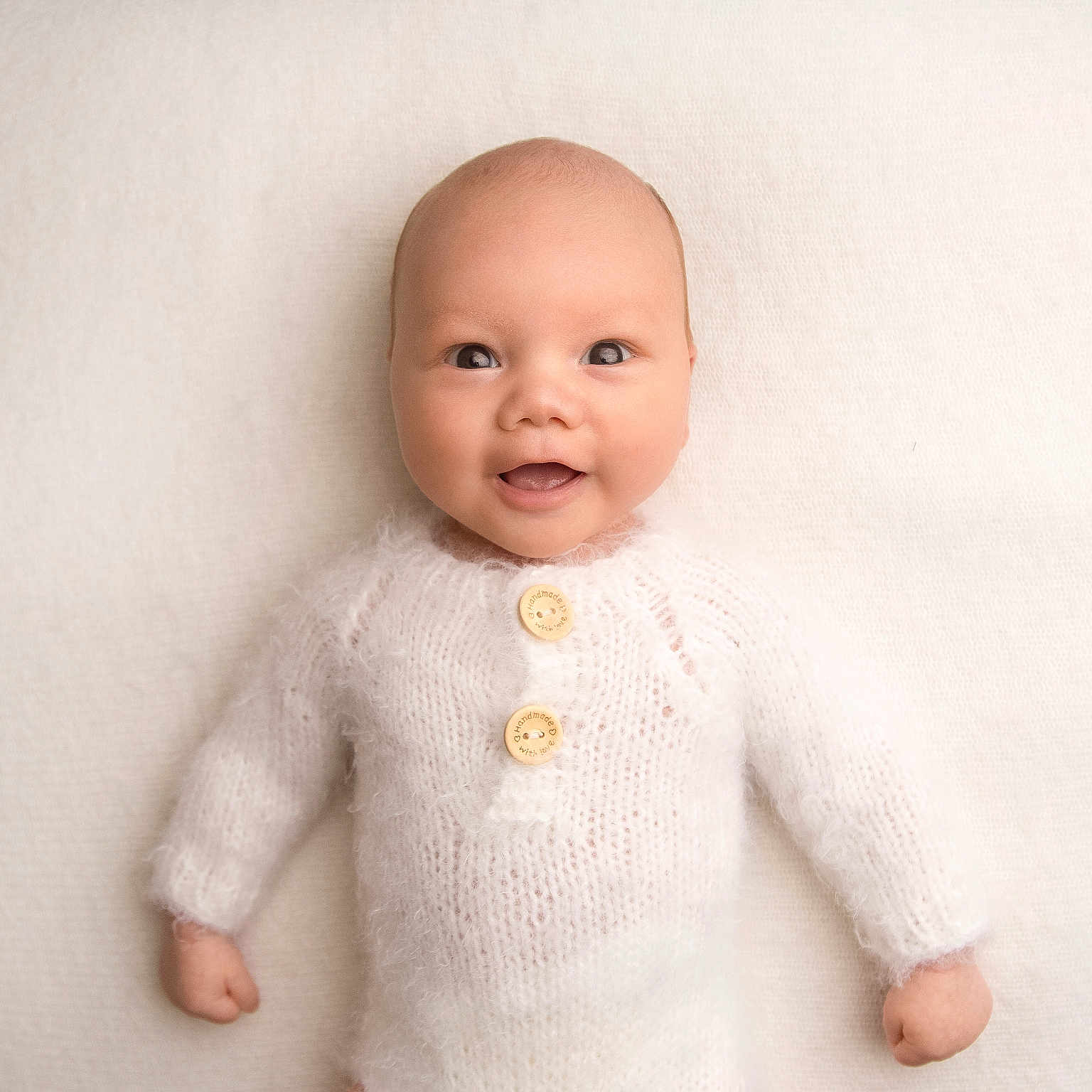 Lucas is registered to the contest to win money with this photo: baby, bodypart, clothing, doll, face, finger, hand, happy, head, knitwear, longsleeve, newborn, person, photography, portrait, sitting, sleeve, smile, sweater, toy