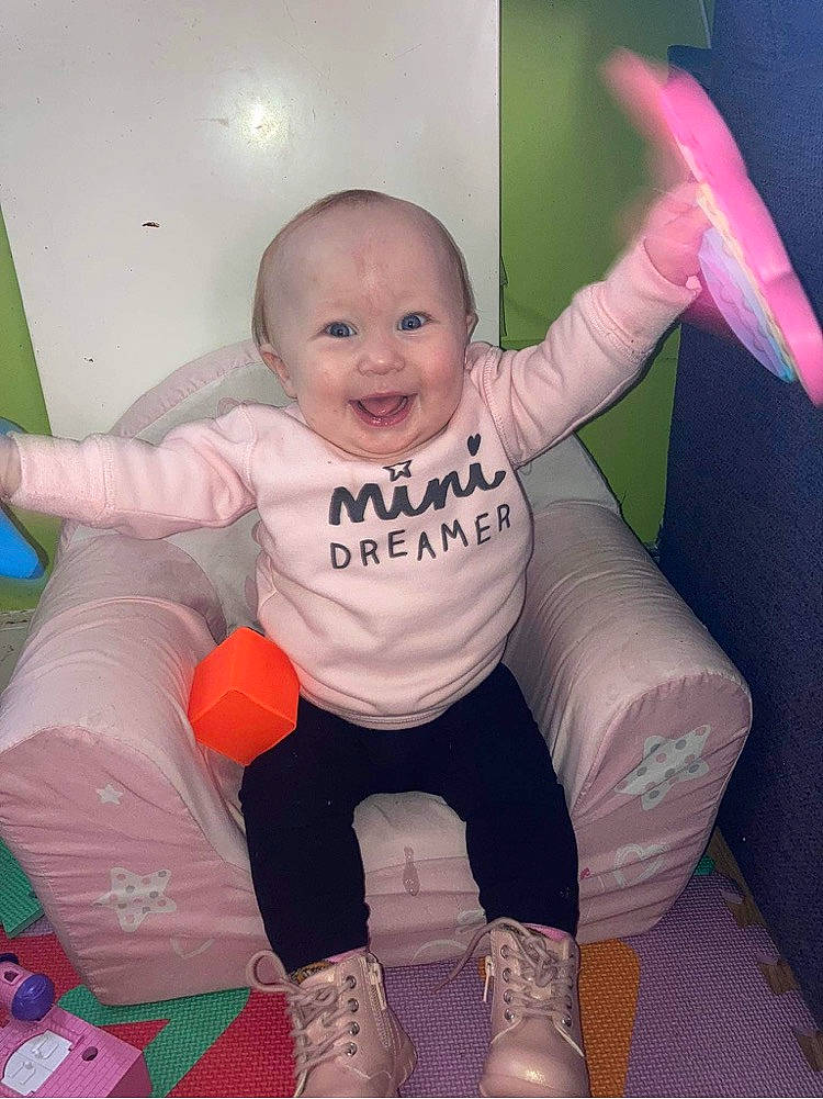 Zayna participe au concours pour gagner de l'argent avec cette photo : baby_toddler_clothing, comfort, eye, face, facial_expression, finger, gesture, hairstyle, happy, head, human_body, joy, leg, mouth, person, pink, product, purple, shoe, skin