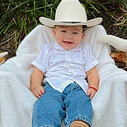 Aziel is registered to the contest to win money with this photo: baby, blanket, blue_jeans, casual_clothing, child, cowboy_hat, cute, footwear, grass, greenery, happy, hat, infant, nature, outdoor, portrait, sitting, smiling, white_shirt, young_child