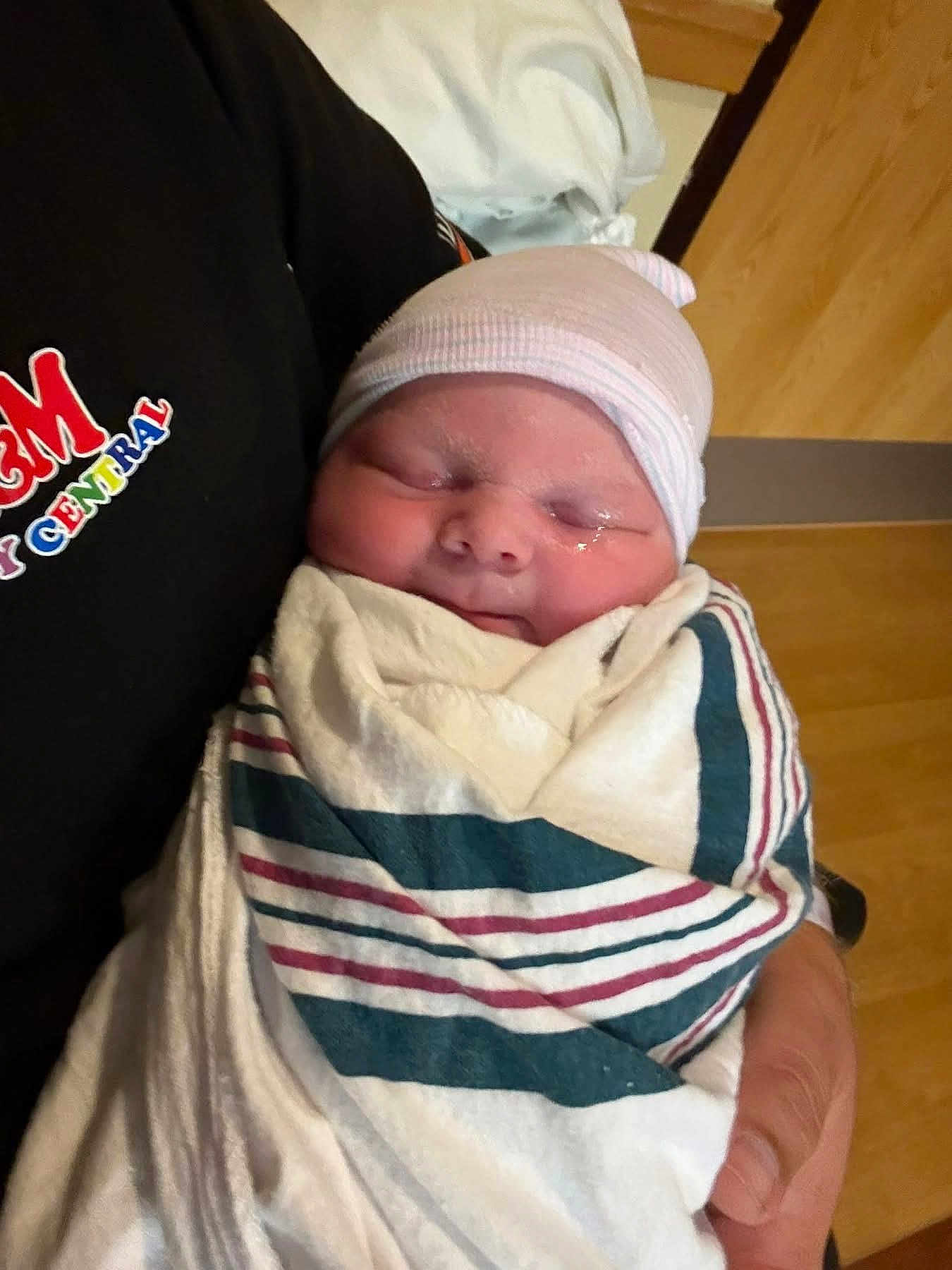 Colton joined the competition — help win amazing prizes! newborn, baby, swaddled, blanket, hat, sleeping, person, hand, indoors, hospital, wood_floor, clothing, closeup, infant, resting, comfort, parent, wrapped, cute, peaceful