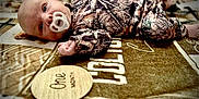 Colton joined the competition — help win amazing prizes! baby, infant, pacifier, camo_clothing, blanket, one_month, lying_down, young_child, face, cute, patterned, soft_texture, newborn, indoor, portrait, child, baby_boy, closeup, floor, resting