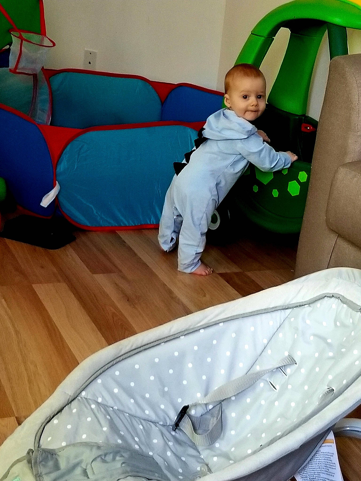 Liam participe au concours pour gagner de l'argent avec cette photo : automotive_exterior, baby_safety, baby_toddler_clothing, child, comfort, couch, flooring, fun, furniture, green, hardwood, leisure, living_room, person, recreation, room, sitting, t_shirt, toddler, white