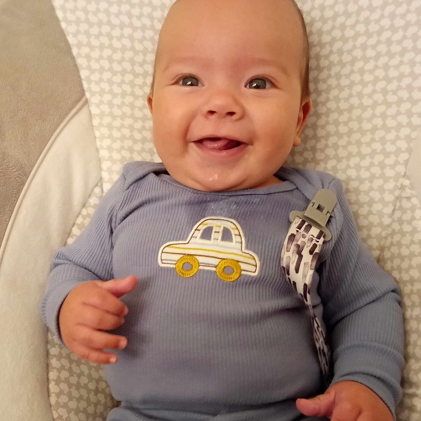 Leland joined the competition — help win amazing prizes! baby, blue_outfit, car_emblem, child, cozy, cushion, cute, drool, eyes, face, happy, head, indoor, infant, lying_down, mouth, patterned_background, portrait, small_hands, smiling