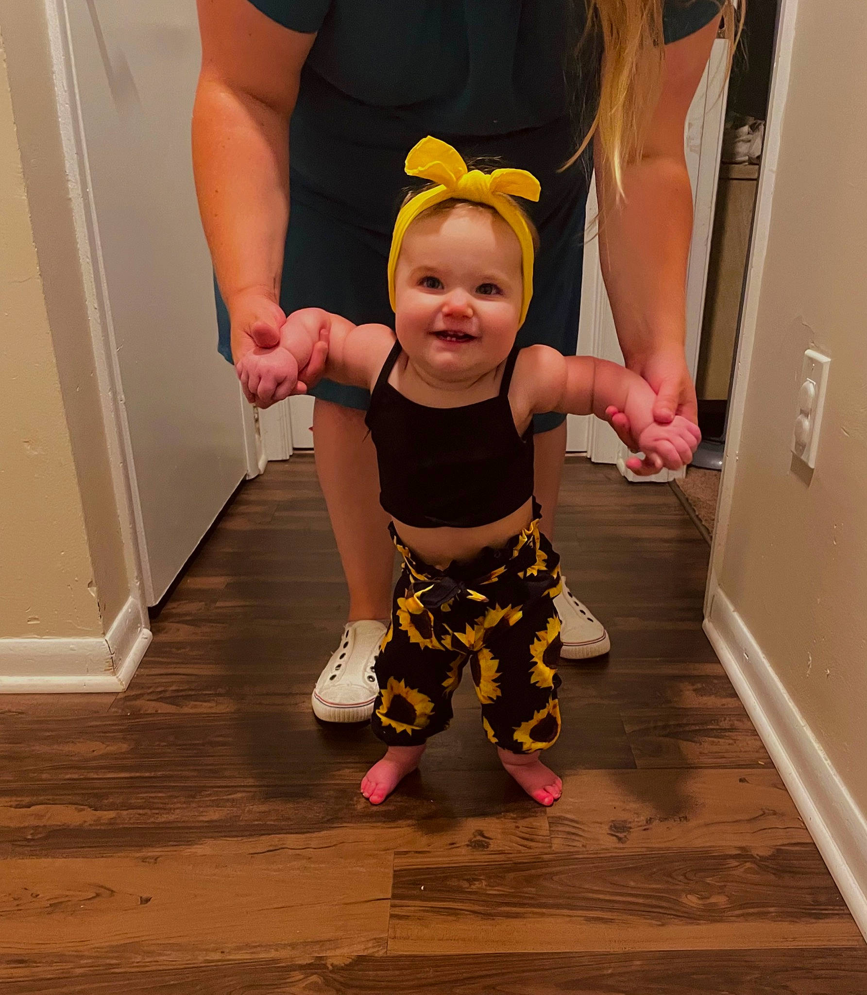 Maisley is registered to the contest to win money with this photo: active_pants, baby, baby_toddler_clothing, barefoot, door, floor, flooring, fun, gesture, happy, hardwood, human_leg, joint, joy, person, sleeve, smile, standing, t_shirt, thumb