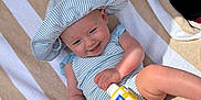 Djynn participe au concours pour gagner de l'argent avec cette photo : baby, child, smiling, hat, sunhat, striped_clothing, striped_towel, beach, sunscreen, sandy, lounge_chair, menu, relaxing, sunny, outdoor, person, infant, summer, vacation, happy