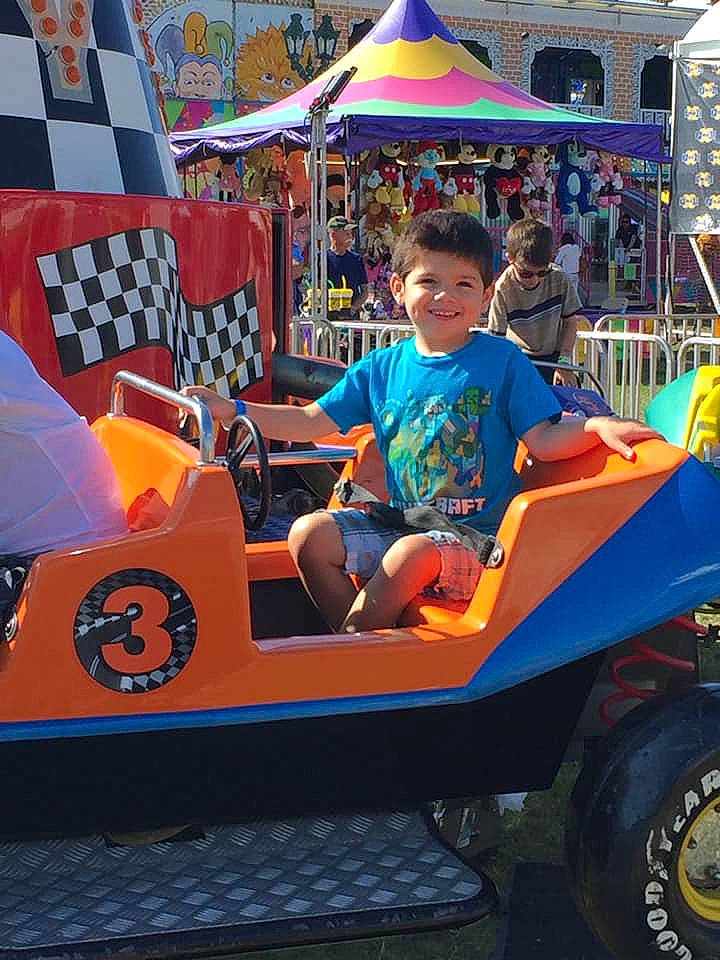 Asher is registered to the contest to win money with this photo: amusement_park, amusement_ride, car, child, fair, festival, fun, games, joy, leisure, nonbuilding_structure, park, person, play, recreation, toddler, tourist_attraction, vacation, vehicle