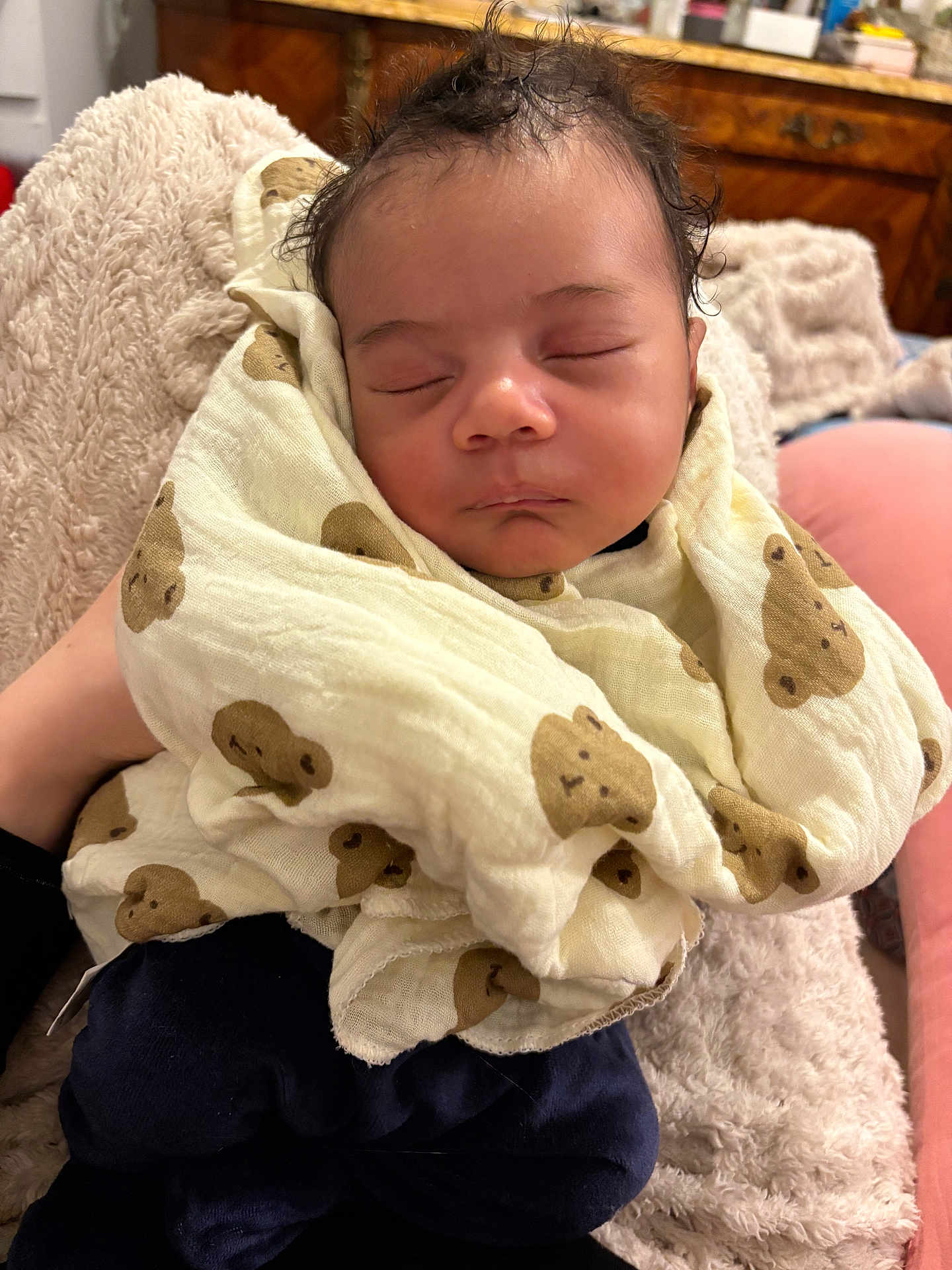 Ousman participe au concours pour gagner de l'argent avec cette photo : baby, sleeping, blanket, teddy_bear_pattern, soft_texture, curly_hair, infant, wrapped, cozy, indoor, person, peaceful, resting, cute, child, portrait, comfort, warm, furniture, home