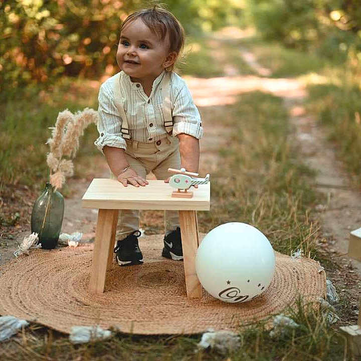 Lorys a rejoint le concours — aidez-le/la à gagner de superbes lots ! balloon, celebration, child, daylight, decor, grass, happy, nature, number_one, outdoor, pampas_grass, pathway, portrait, round_mat, shoes, smiling, suspenders, toddler, vase, wooden_stool