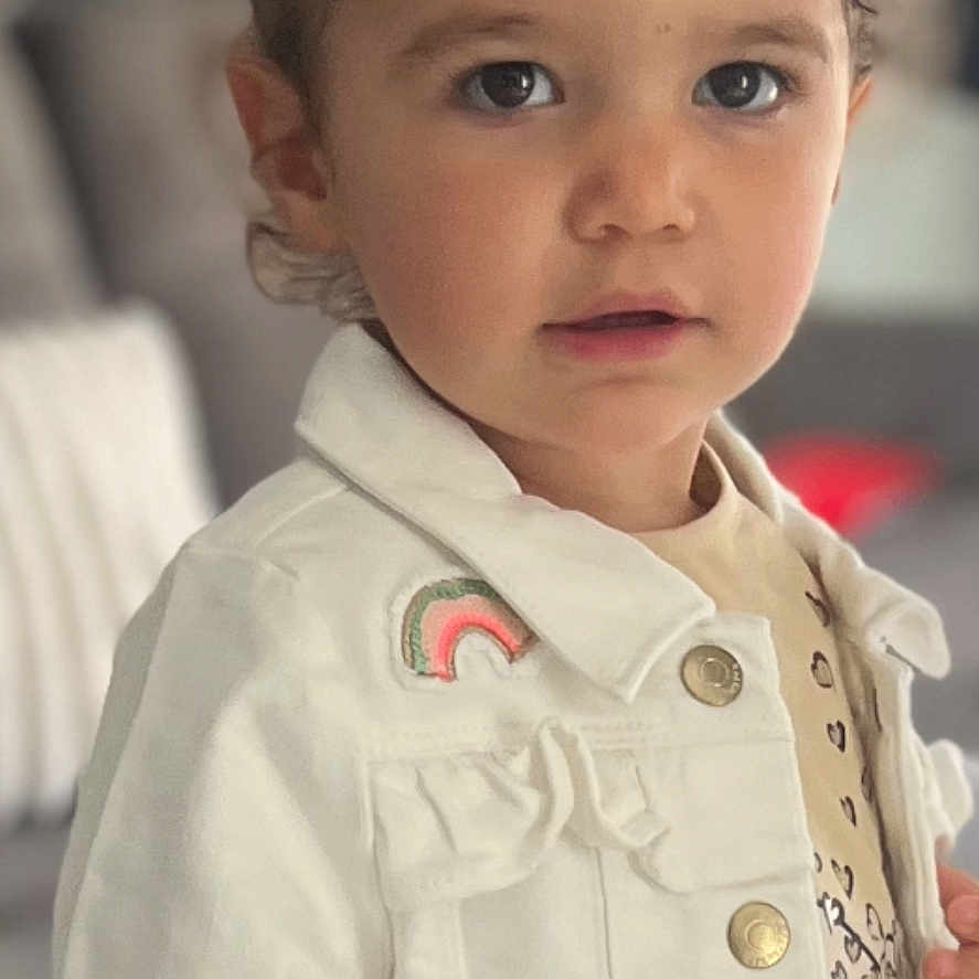 Stella participe au concours pour gagner de l'argent avec cette photo : baby, bodypart, clothing, coat, dress, face, finger, formalwear, hair, hand, happy, head, jacket, longsleeve, overcoat, person, photography, portrait, shirt, sleeve