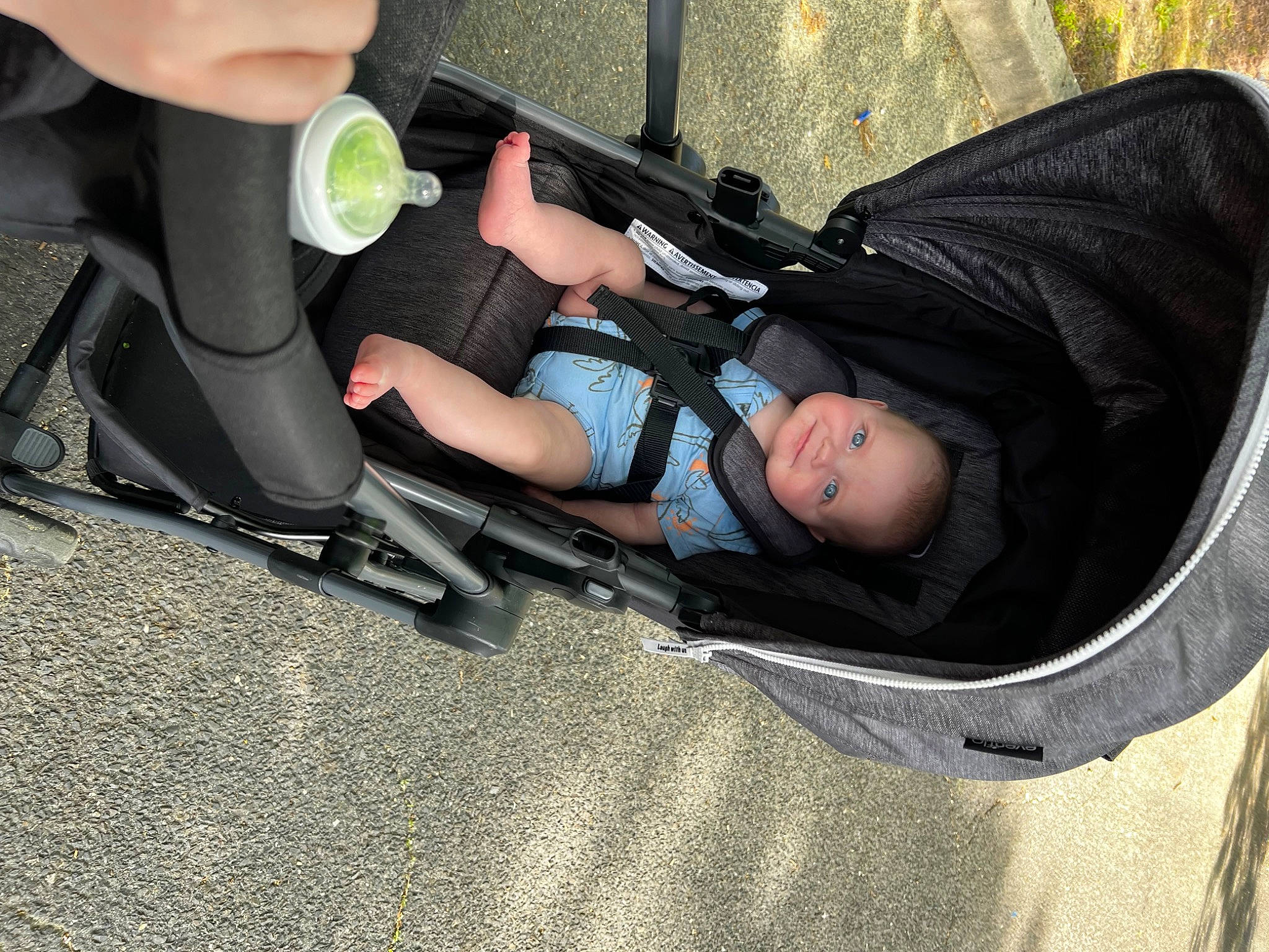 Nathaniel is registered to the contest to win money with this photo: auto_part, automotive_exterior, automotive_tire, baby, baby_carriage, baby_products, child, comfort, fun, grass, human_leg, joy, knee, leg, person, personal_protective_equipment, recreation, sitting, thigh, tire