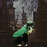 Mini is registered to the contest to win money with this photo: animal, black_and_white, cat, cemetery, costume, crosses, dinosaur_costume, dramatic, funny, gloomy, gothic, graveyard, green, outdoor, pet, portrait, standing, surreal, tombstones, tuxedo_cat