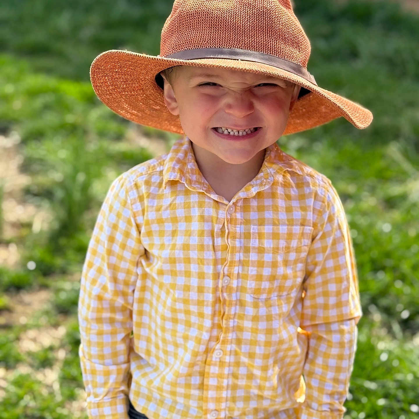 Noah joined the competition — help win amazing prizes! boy, casual_clothing, checkered_shirt, child, cute, daylight, expression, grass, happy, hat, nature, outdoor, person, playful, portrait, smiling, standing, sunny, toy, yellow_shirt