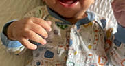 Ryan Christopher is registered to the contest to win money with this photo: baby, child, infant, smiling, happy, portrait, face, eyes, mouth, hands, onesie, patterned_clothing, blanket, bedding, lying_down, indoors, closeup, cheerful, cozy, photography