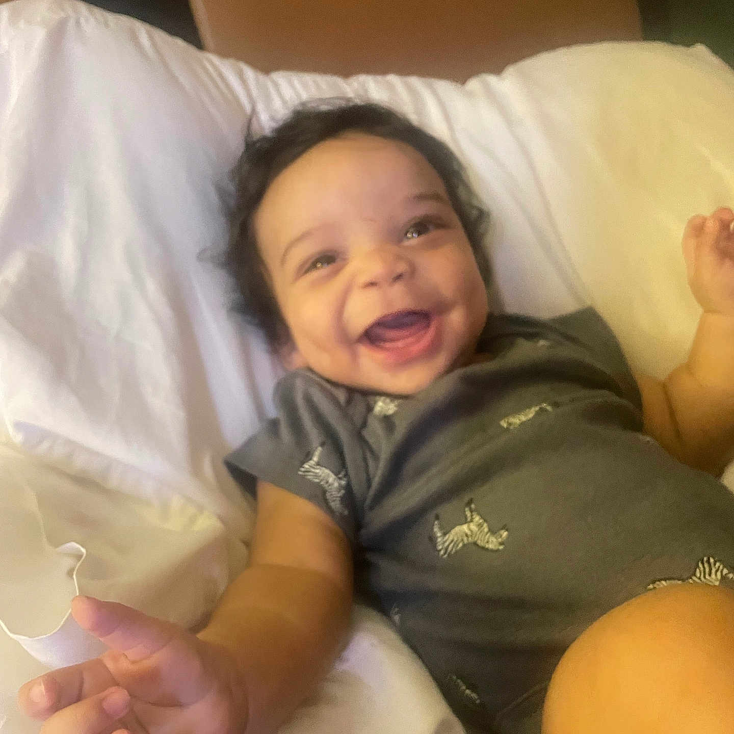 Ryan Christopher joined the competition — help win amazing prizes! baby, infant, child, smiling, laughing, portrait, face, eyes, hair, foot, hand, onesie, clothing, pillow, bedding, bed, indoor, cozy, happy, relaxed