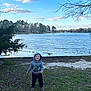 Wyatt joined the competition — help win amazing prizes! child, boy, hoodie, smiling, grass, lake, water, trees, sky, clouds, outdoor, nature, boots, happy, young, casual_clothing, daytime, landscape, bare_trees, shoreline