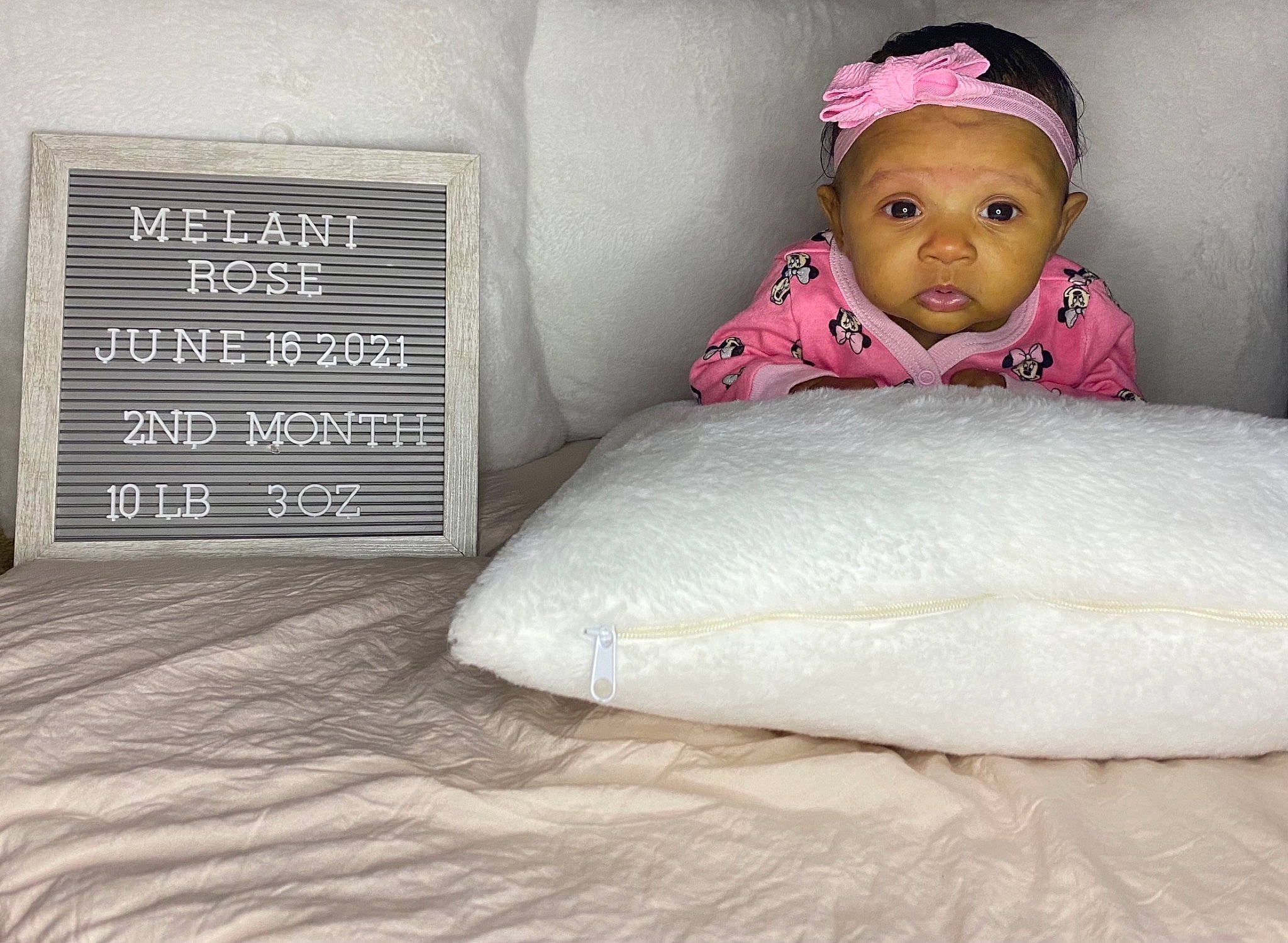 Melani is registered to the contest to win money with this photo: baby, baby_sleeping, baby_toddler_clothing, bedding, cap, comfort, eye, floor, flooring, font, fur, grey, illustration, linens, magenta, person, pillow, room, textile, throw_pillow