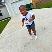 Kisaani joined the competition — help win amazing prizes! toddler, child, smiling, braided_hair, white_tshirt, hello_kitty, denim_shorts, white_sneakers, driveway, concrete, house, garage, green_trash_bins, outdoor, daylight, happy, person, casual_clothing, suburban, playful