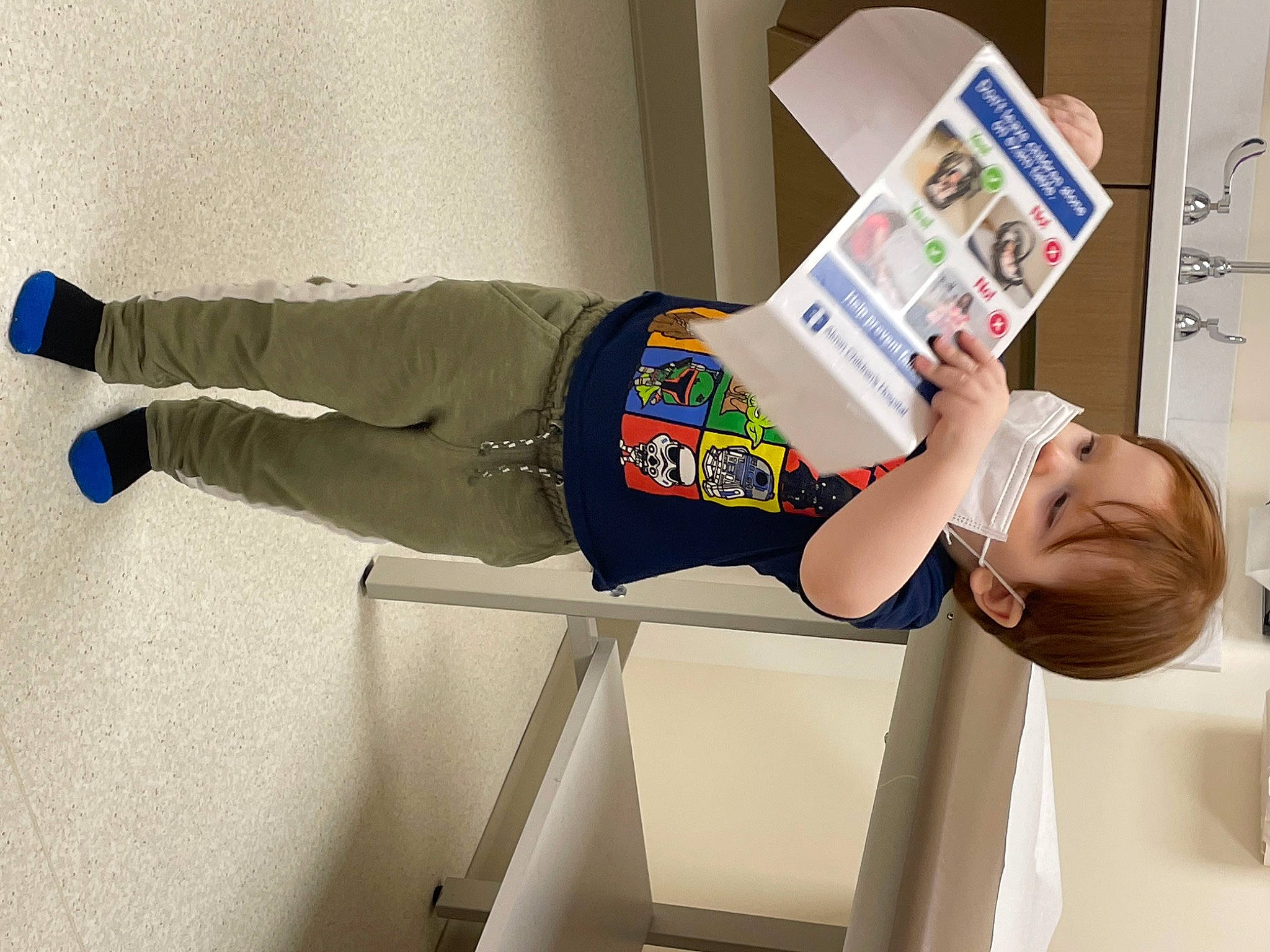 Donovan is registered to the contest to win money with this photo: arm, balance, child, cleanliness, elbow, electric_blue, happy, human_leg, knee, person, room, sleeve, sportswear, standing, sweatpant, t_shirt, thigh, toddler, walking_shoe, wrist