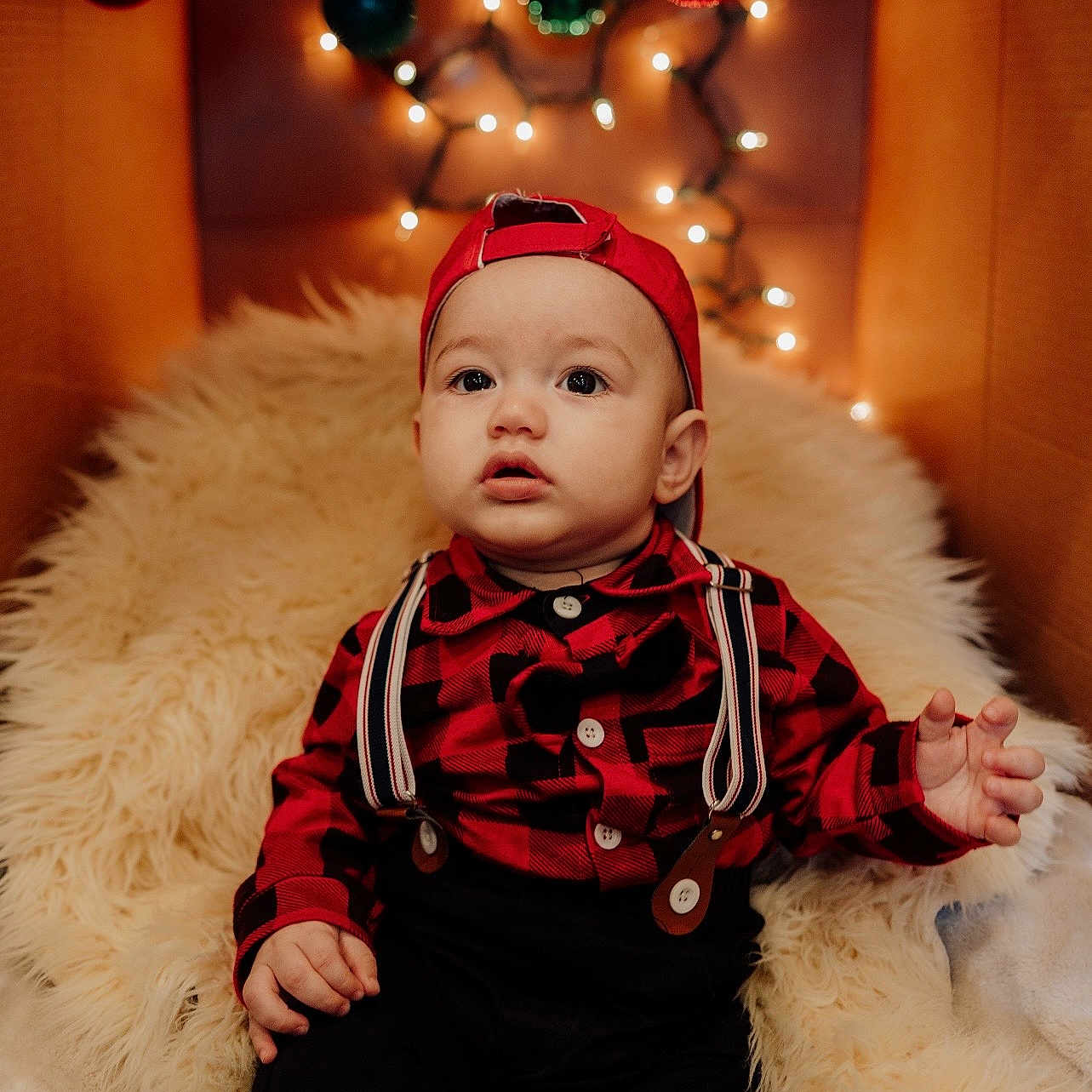 Gadiel joined the competition — help win amazing prizes! baby, cardboard_box, child, cozy, curious, cute, decorations, festive, fluffy_rug, holiday, indoors, ornaments, plaid_shirt, portrait, red_cap, sitting, string_lights, suspenders, warm_lighting, young