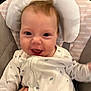 baby, infant, smile, face, onesie, cushion, baby_chair, hand, tattoo, happy, indoor, comfort, clothing, child, cute, young, person, skin, head, expression