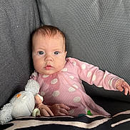 Darcie Rose joined the competition — help win amazing prizes! baby, infant, child, polka_dot, pink_clothing, plush_toy, pacifier, couch, sofa, grey_fabric, hand, face, eyes, indoor, portrait, cute, young, seated, soft_toy, relaxed