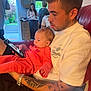 Darcie Rose joined the competition — help win amazing prizes! baby, man, tattoo, phone, indoor, couch, family, child, window, banner, kitchen, woman, casual, red_couch, clothing, portrait, home, watch, tattooed_arm, curious