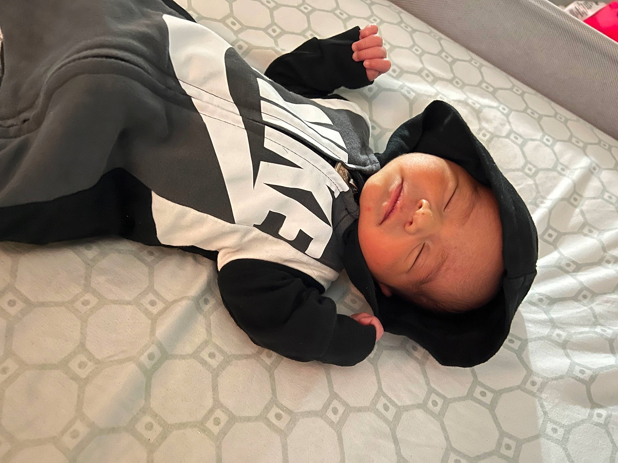 Koen is registered to the contest to win money with this photo: black_hair, carmine, child, comfort, elbow, floor, flooring, human_leg, knee, linens, nap, pattern, person, room, sitting, sleep, sleeve, sock, sportswear, thigh