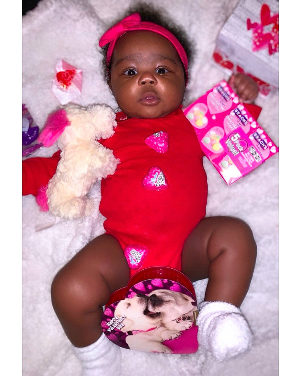 Alaiyah is registered to the contest to win money with this photo: arm, baby, baby_toddler_clothing, beauty, comfort, face, finger, happy, headwear, human, leg, magenta, person, pink, purple, red, skin, sleeve, textile, thigh