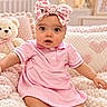 Leah is registered to the contest to win money with this photo: baby, child, infant, portrait, sitting, pink_dress, headband, floral_bow, teddy_bear, stuffed_animal, nursery, blanket, cushion, heart_pattern, indoors, smiling, wide_eyes, furniture, soft_lighting, photography