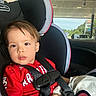 toddler, child, car_seat, red_shirt, seatbelt, car_interior, window, gas_station, phillips_66, vehicle, safety, young_child, portrait, daylight, curious_expression, hair, face, person, seat, travel