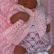 Theresa is registered to the contest to win money with this photo: baby, newborn, sleeping, pink_blanket, knit_hat, crocheted_sweater, baby_clothes, booties, soft_texture, infant, cute, cozy, patterned_shorts, adorable, child, portrait, resting, indoor, warm, peaceful