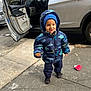 beanie, blue, car, casual, child, cookie, dinosaur_pattern, footwear, gray_car, happy, open_car_door, outdoor, puffer_jacket, sidewalk, smiling, street, toddler, urban, winter_clothing, young_child