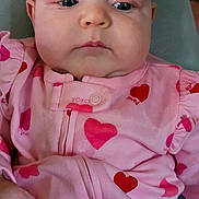 Harper joined the competition — help win amazing prizes! baby, infant, pink_onesie, hearts, clothing, face, cheeks, hand, chair, indoor, person, cute, young_child, portrait, seated, soft_furniture, expressionless, closeup, newborn, home
