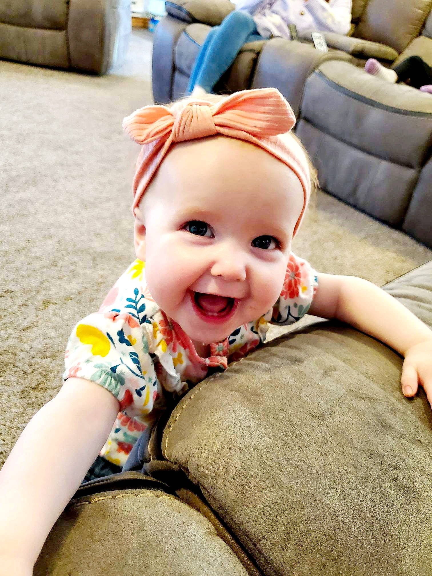 Ari is registered to the contest to win money with this photo: baby, baby_toddler_clothing, cap, child, comfort, couch, face, flooring, fun, grass, happy, head, joy, laugh, leisure, person, play, recreation, selfie, sitting