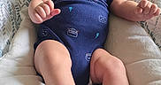 Valentino joined the competition — help win amazing prizes! baby, baby_seat, baby_toys, blanket, blue_onesie, carpet, child, cushion, cute, fabric, foot, hand, happy, home, indoor, infant, person, playpen, relaxed, smiling