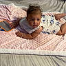 Ariyah joined the competition — help win amazing prizes! baby, infant, child, portrait, lying_down, bed, blanket, pink_blanket, floral_outfit, dress, tablet, toy, bedroom, bedding, face, brown_hair, looking_at_camera, curious, indoor, cozy