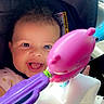 baby, child, infant, smiling, happy, portrait, car_seat, car, toy, rattle, pink_toy, purple_toy, blanket, sitting, face, eyes, open_mouth, sunlight, indoor, close_up