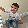 toddler, child, smiling, happy, sitting, carpet, jeans, ripped_jeans, white_tshirt, palm_angels, socks, indoor, furniture, hand, face, person, young_child, short_hair, casual_clothing, home