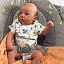 arm, baby, baby_seat, blanket, clothing, curious, expression, face, furniture, graco, hand, head, indoor, infant, leg, onesie, seated, soft_texture, straps, table