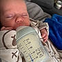 baby, blanket, bottle, closed_eyes, couch, cozy, cute, face, feeding, hand, indoors, infant, milk, newborn, onesie, peaceful, person, resting, sleeping, soft_fabric