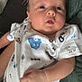 Leo is registered to the contest to win money with this photo: baby, child, clothing, comfort, couch, cute, expression, fabric, face, hand, holding, indoor, infant, newborn, onesie, person, pillow, portrait, skin, soft
