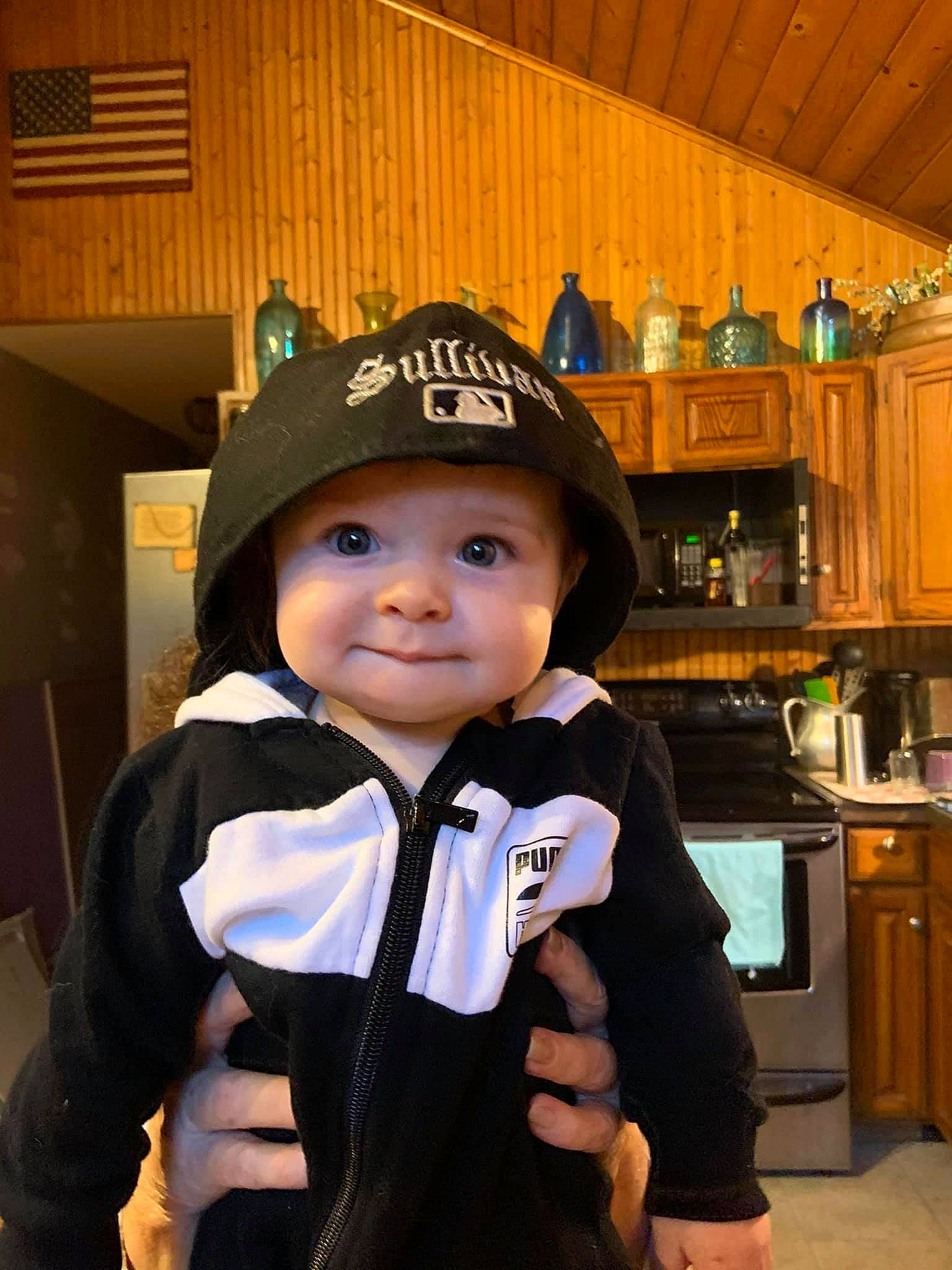 Conor is registered to the contest to win money with this photo: baseball_cap, cabinetry, cap, child, countertop, electric_blue, fashion_accessory, fun, hat, headgear, headwear, home_appliance, kitchen, kitchen_appliance, microwave_oven, person, personal_protective_equipment, room, sleeve, smile