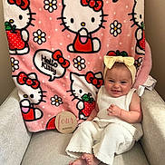 Payton joined the competition — help win amazing prizes! baby, child, infant, smile, headband, knitwear, white_clothing, chair, blanket, hello_kitty, pink, pattern, flower, apple, wooden_sign, months, indoor, cute, milestone, happy
