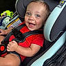baby, child, car_seat, smile, red_shirt, happy, infant, seatbelt, safety, blue_eyes, cute, portrait, car_interior, young_child, person, seat, clothing, baby_boy, closeup, fun