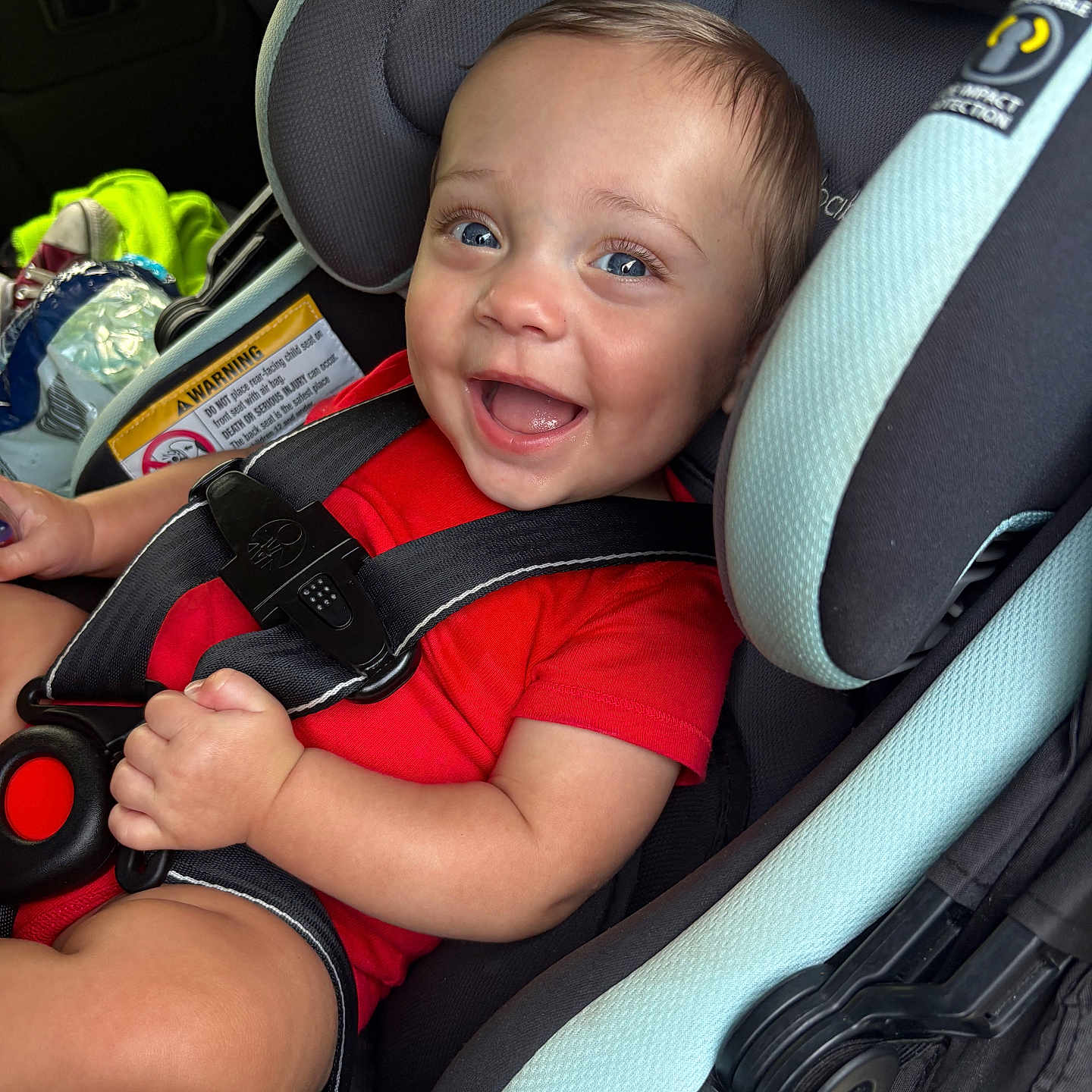 Brantlee joined the competition — help win amazing prizes! baby, child, car_seat, smile, red_shirt, happy, infant, seatbelt, safety, blue_eyes, cute, portrait, car_interior, young_child, person, seat, clothing, baby_boy, closeup, fun