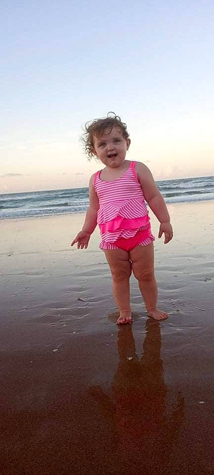 Molly joined the competition — help win amazing prizes! baby_toddler_clothing, beach, body_of_water, coastal_and_oceanic_landforms, fun, gesture, happy, horizon, human_body, people_in_nature, people_on_beach, person, sand, shorts, sky, sleeve, t_shirt, thigh, toddler, water