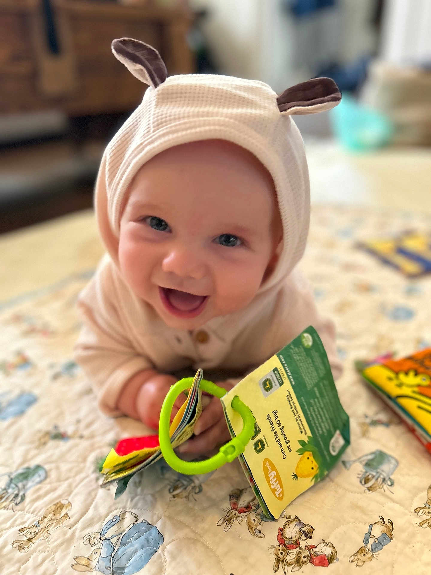 Oscar joined the competition — help win amazing prizes! baby, child, smiling, hood, ears, toy, book, quilt, pattern, colorful, indoor, happy, cute, infant, playful, hands, face, bright, young, cozy