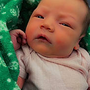 Lila Bunny joined the competition — help win amazing prizes! baby, newborn, infant, blanket, green_blanket, pink_clothing, wrapped, closeup, face, head, skin, hand, indoor, cute, sleepy, young_child, portrait, soft_texture, cozy, resting