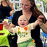 baby, child, infant, smiling, happy, portrait, adults, family, outdoor, backyard, party, picnic, balloons, colorful_clothing, green_shorts, black_shirt, woman, holding, seated, sunlight